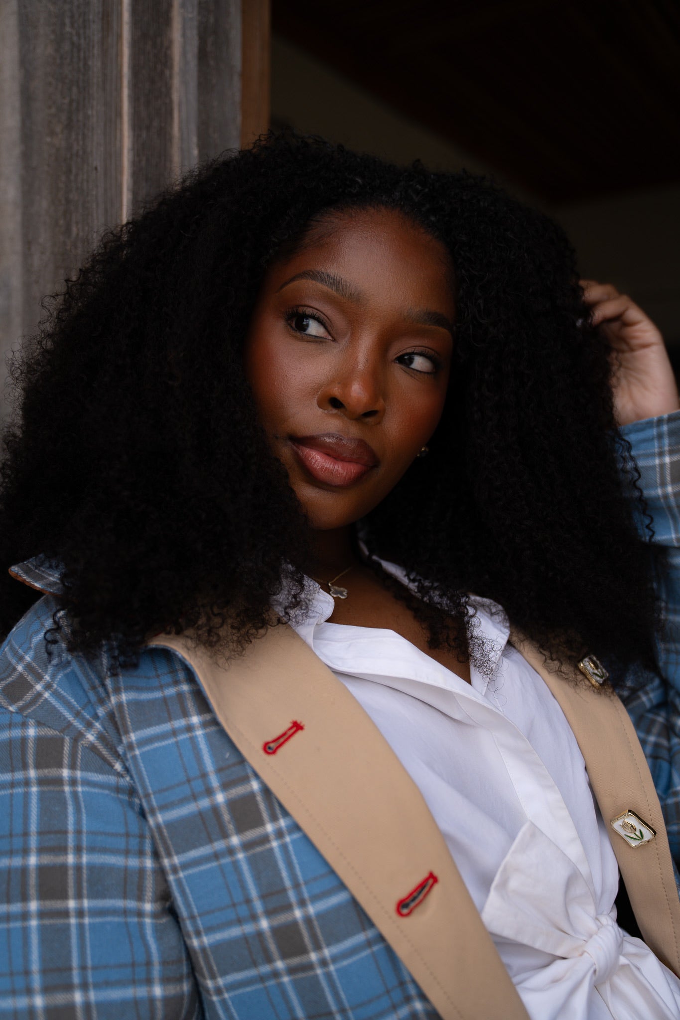 Woman wearing a blue plaid jacket with a beige sash over a white shirt.womens barn jacket power woman