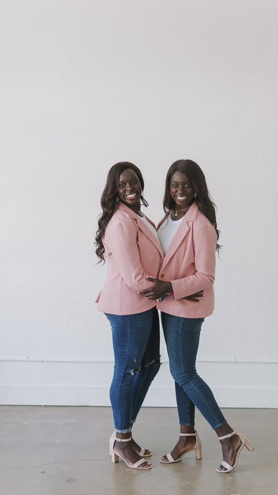 Two women pose together in PWR WMN’s PWRFUL in Pink Blazer, styled with white tops and jeans.