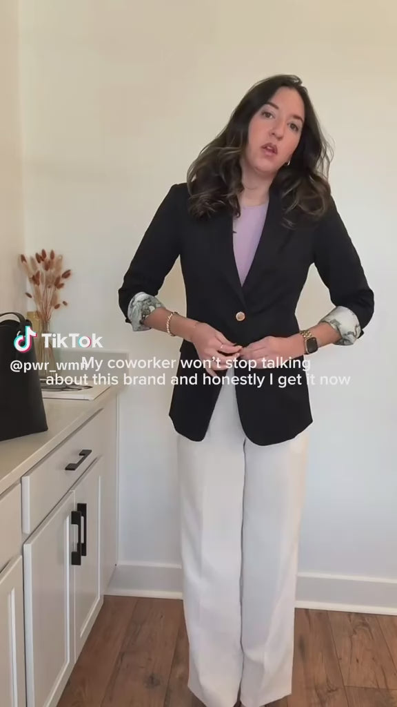 Content creator reviews PWR WMN’s Miss Noir Black Oversized Blazer, styled with a lavender top and white trousers.