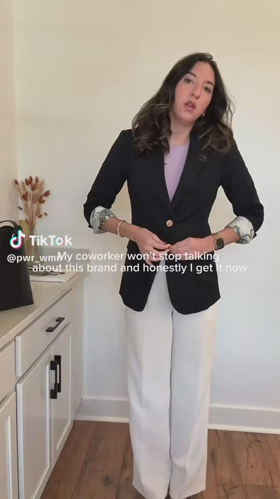 Content creator reviews PWR WMN’s Miss Noir Black Oversized Blazer, styled with a lavender top and white trousers.
